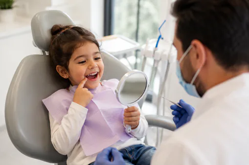 A young child having her teeth checked in the chair at a first orthodontic evaluation
